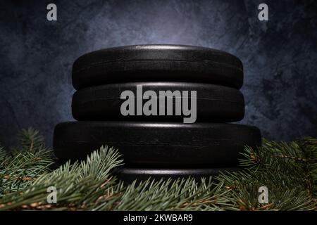 Hantelglockengewichtsteller und Weihnachtsbaumzweige. Fitness-Feiertage Winterzusammensetzung. Fitnessstudio und Sporttrainingskonzept. Stockfoto