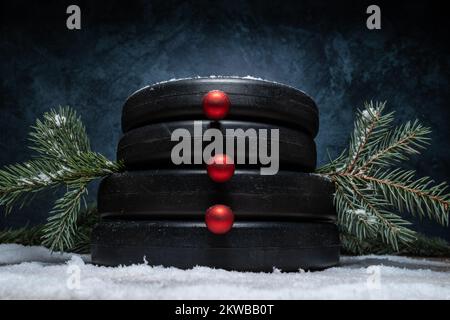 Die Kraftplatten für die Kurzhanteln im Fitnessstudio sind wie Schneemänner aufeinander gestapelt. Fitness-Feiertage, Winter-Workout-Komposition für Weihnachten. Stockfoto