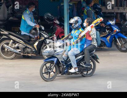 SAMUT PRAKAN, THAILAND, Okt 19 2022, Ein Taxifahrer auf einem Motorrad fährt mit einer Frau und trägt Flaggen Stockfoto