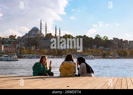 Türkische Jugend. Hijabi und nicht-Hijabi-Freunde in der Nähe des Goldenen Horns in Istanbul. Religionen und weltliche junge Türken. Istanbul Turkiye - 10.4.2022 Stockfoto