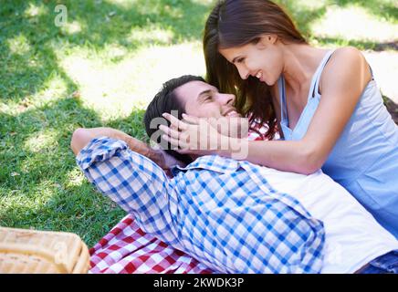 Liebe ist nicht großartig. Ein glückliches junges Paar, das ein Picknick in der Sommersonne genießt. Stockfoto