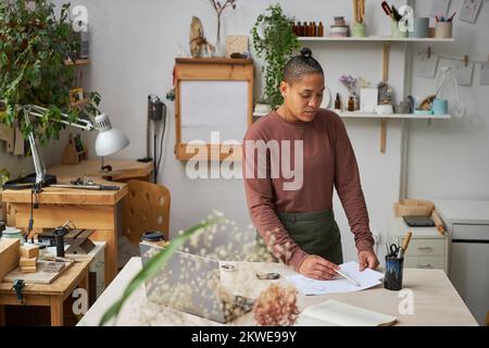 Porträt einer jungen Künstlerin, die im Kreativstudio arbeitet und neue Designs zeichnet Stockfoto