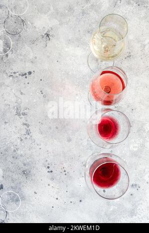 Gläser mit verschiedenen Weinsorten auf weißem Hintergrund. Wunderschöner abstrakter Weinhintergrund. Draufsicht Stockfoto