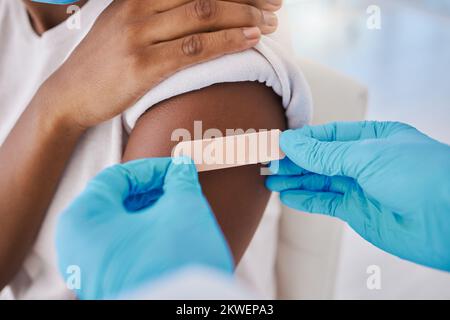 Pflasterverband am Arm für Covid-Impfstoff, Injektion und Heilung des Patienten durch einen Arzt im Krankenhaus. Nahaufnahme von Grippe-Jab, antivirale Impfung und Gesundheit Stockfoto
