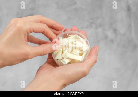 Die Hand einer Frau nimmt schwedische Schnecken aus einer Schachtel, Nahaufnahme Stockfoto