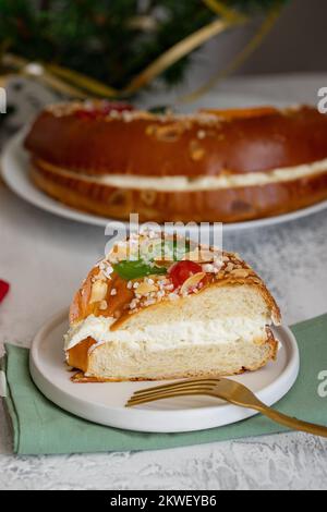 Roscon de reyes, traditionelles spanisches Weihnachtsdessert, serviert am Morgen von Reyes, auch bekannt als Epiphany am 6. Januar. Festliche Tischgestaltung mit Swee Stockfoto