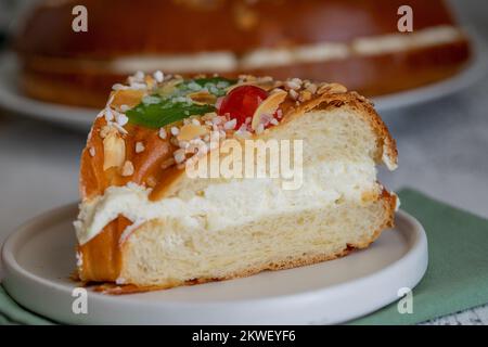 Ein Stück Roscon de reyes, spanischer Weihnachtskuchen zur Feier von Epiphany oder Dia de Reyes Magos, Tag der drei Weisen. Nahaufnahme und Detaile-Bild. Stockfoto