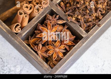 Verschiedene Gewürze Zimt, Nelken und Sternanis auf Holzkiste. Traditioneller Weihnachtsgeruch und Hintergrund der Wintergewürze. Stockfoto