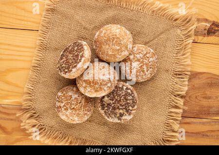 Mehrere süße leckere Lebkuchen-Kekse mit Jute Serviette auf Holztisch, Makro, Draufsicht. Stockfoto