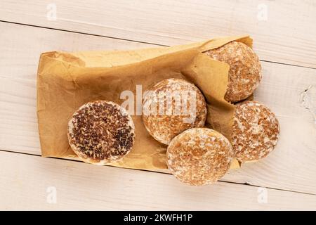 Mehrere süße leckere Lebkuchen mit Papierbeutel auf Holztisch, Makro, Draufsicht. Stockfoto