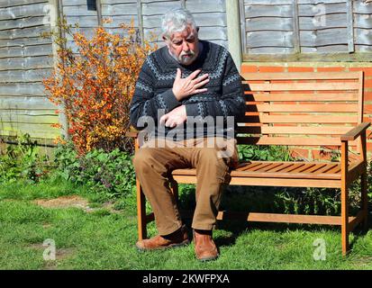 Senioren oder Senioren, die sich vor Schmerzen an der Brust festhalten. Herzinfarkt, Angina pectoris oder Brustprobleme. Stockfoto