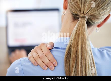 Rezeptionistin mit Nackenschmerzen, Burnout und Stress, die an einem Laptop in ihrem Büro arbeitet. Weibliche Mitarbeiterin mit Verletzung, Muskelverletzung und Müdigkeit Stockfoto