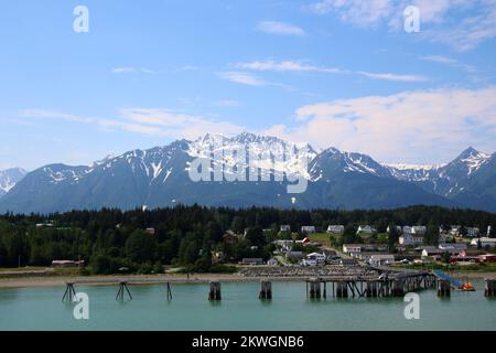 Blick auf Fort William H. Seward vom Chilkoot Inlet und die Berge im Hintergrund, Haines, Alaska, Stockfoto