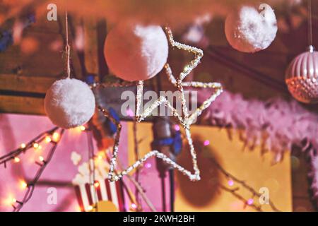 Pinkfarbene flauschige Weihnachtsbälle und Gerlandbälle dekorieren das Teenagerzimmer zu Weihnachten. Stockfoto