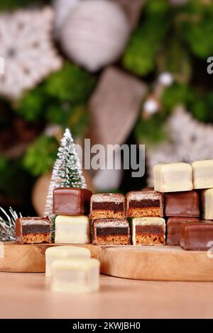 Traditionelle deutsche Süßigkeiten namens Dominosteine. Weihnachtsbonbons, bestehend aus Lebkuchen, Gelee und Marzipanschichten mit braunem und weißem Cho Stockfoto