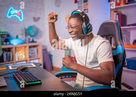 Junger afroamerikanischer Gamer, der das Spiel gewinnt, feiert den Sieg im Online-Spiel Stockfoto
