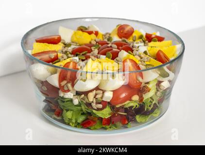 Salat mit gevierteltem Ei, Tomaten, Salat und Getreide in einer Schüssel Stockfoto