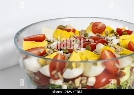 Salat mit gevierteltem Ei, Tomaten, Salat und Getreide in einer Schüssel Stockfoto