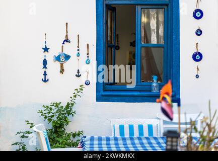 Türkisches Café im mediterranen griechischen Stil mit einem blauen Fenster und einem Tisch zum Abendessen, dekoriert mit wunderschönen türkischen nationalen Dekorationen. Hochwertiges Foto Stockfoto