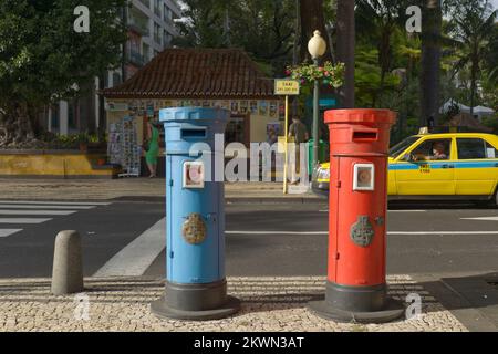 Funchal, Madeira - Straßenszene mit roten und blauen Postfächern, Zebraüberquerung und gelbem Taxi Stockfoto