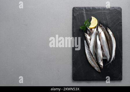 Lodde aus rohem frischem Fisch. Grauer Hintergrund. Draufsicht. Stockfoto