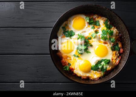 Shakshuka-Eier schließen. Pochierte Eier in einer scharfen Tomaten- und Pfeffersoße. Traditionelles jüdisches Rührei. Traditionelle Shakshuka-Eier. Speicherplatz kopieren Stockfoto