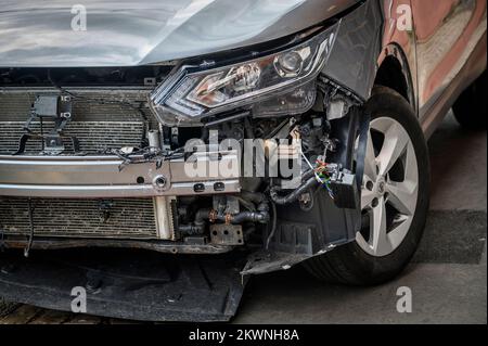 Nahaufnahme von Schäden an der Vorderseite eines Autos nach einem Verkehrsunfall. Stockfoto
