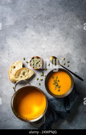 Kürbissuppe im Topf am Steintisch. Stockfoto