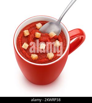 Instant-Tomatensuppe mit Croutons in roter Tasse isoliert, Draufsicht Stockfoto