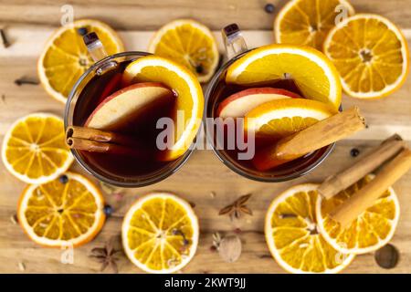 Glühwein in durchsichtigen Bechern mit Apfel- und Orangenscheiben, heiße aromatisierte Rotwein-alkoholische Getränke, Draufsicht, Nahaufnahme Foto Stockfoto