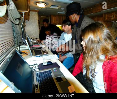 Severe Storms and Tornadoes, Madisonville, Ky, 6. Dezember 2005 – (von links nach rechts) die Candidate Services Specialists Kristy Jackson und Tina Wells (stehend) prüfen die Internet-Anwendungen von Mary Foster, Dwayne Laughary und Ashley Skimmerhorn. Die Bezirke Hopkins und Marshall im Westen Kentuckys wurden am 15. Dezember für Schäden, die durch F4 Tornados verursacht wurden, als förderfähig erklärt. Gewinnen Sie ein Foto von Henderson/FEMA. Fotos zu Katastrophen- und Notfallmanagementprogrammen, Aktivitäten und Beamten Stockfoto