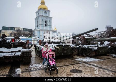 Kiew, Ukraine. 26.. November 2022. Eine Frau mit Kinderwagen läuft an zerstörten russischen Militärfahrzeugen vorbei, die in Zentral-Kiew ausgestellt sind. Am 24. februar 2022 marschierten russische Truppen in die ukraine ein und begannen damit einen Konflikt, der die Zerstörung und eine humanitäre Krise provoziert hat. Am 24. Februar 2022 marschierten russische Truppen in die Ukraine ein und lösten einen Konflikt aus, der zu Zerstörung und einer humanitären Krise geführt hat. Kredit: SOPA Images Limited/Alamy Live News Stockfoto
