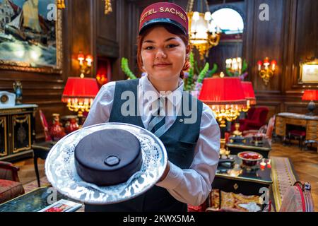 Eine Kellnerin des Hotel Sacher zeigt eine köstliche Sachertorte in der Lobby des Hotel Sacher Vienna Austria. Das Hotel Sacher ist ein 5-Sterne-Luxushotel Stockfoto