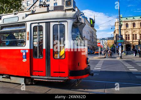 Die Wiener Straßenbahn, auch Strassenbahn genannt, ist eine alte und traditionelle moderne Straßenbahn, die an der berühmten ringstraße im Operring im Stadtzentrum vorbeifährt. Stockfoto