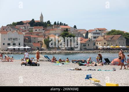 04.09.2016., Primosten, Kroatien - der Sommer ist vorbei und verkündete das schlechtere Wetter. Am Primosten Beach gibt es immer noch Gäste, die gerne schwimmen und sich sonnen, während einige Bücher oder Zeitungen lesen Stockfoto