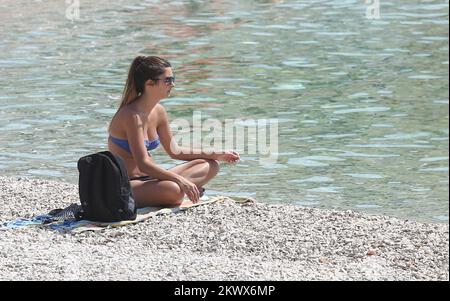 04.09.2016., Primosten, Kroatien - der Sommer ist vorbei und verkündete das schlechtere Wetter. Am Primosten Beach gibt es immer noch Gäste, die gerne schwimmen und sich sonnen, während einige Bücher oder Zeitungen lesen Stockfoto