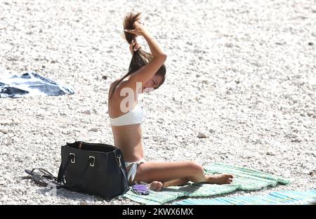 04.09.2016., Primosten, Kroatien - der Sommer ist vorbei und verkündete das schlechtere Wetter. Am Primosten Beach gibt es immer noch Gäste, die gerne schwimmen und sich sonnen, während einige Bücher oder Zeitungen lesen Stockfoto