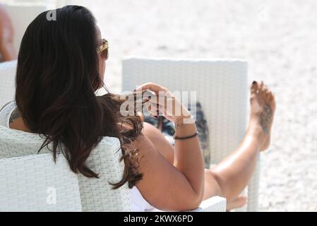 04.09.2016., Primosten, Kroatien - der Sommer ist vorbei und verkündete das schlechtere Wetter. Am Primosten Beach gibt es immer noch Gäste, die gerne schwimmen und sich sonnen, während einige Bücher oder Zeitungen lesen Stockfoto