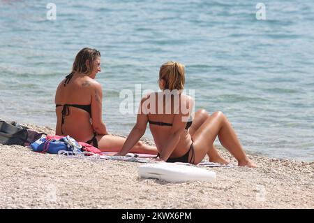 04.09.2016., Primosten, Kroatien - der Sommer ist vorbei und verkündete das schlechtere Wetter. Am Primosten Beach gibt es immer noch Gäste, die gerne schwimmen und sich sonnen, während einige Bücher oder Zeitungen lesen Stockfoto