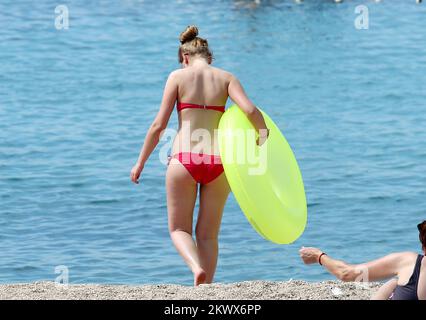 04.09.2016., Primosten, Kroatien - der Sommer ist vorbei und verkündete das schlechtere Wetter. Am Primosten Beach gibt es immer noch Gäste, die gerne schwimmen und sich sonnen, während einige Bücher oder Zeitungen lesen Stockfoto