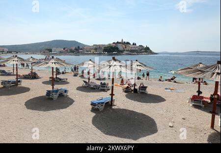 04.09.2016., Primosten, Kroatien - der Sommer ist vorbei und verkündete das schlechtere Wetter. Am Primosten Beach gibt es immer noch Gäste, die gerne schwimmen und sich sonnen, während einige Bücher oder Zeitungen lesen Stockfoto