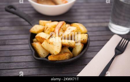 Spanische traditionelle Vorspeise Patatas bravas auf einer kleinen gusseisernen Pfanne Stockfoto