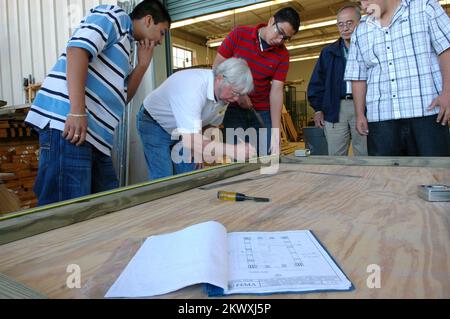 Severe Storms and Tornadoes, Deland, FL, 23. Februar 2007 FEMA-Experte Cris Nery (hinten, blaue Jacke) sieht zu, wie die Schüler von Deland High School Holding Shop unter der Leitung ihres Lehrers Bill Paige an der Konstruktion einer FEMA-Modellstruktur zur Risikominderung arbeiten. Die FEMA fördert den Einsatz mildernder Bautechniken in Gebieten, die von Naturkatastrophen bedroht sind. Mark Wolfe/FEMA.. Fotos zu Katastrophen- und Notfallmanagementprogrammen, Aktivitäten und Beamten Stockfoto