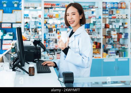 Porträt eines jungen Affable-Apothekers und qualifizierter Pharmazie-, Medikamenten-Pillen-Behältnis- oder Flaschenmodell für Kopierraum in der Apotheke. Ein Drogendealer Stockfoto
