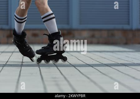 Teilansicht eines Mannes in Rollschuhen, der draußen Tricks macht, Bestandsbild Stockfoto