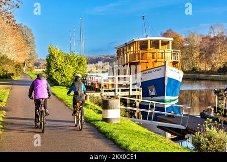 Caledonian Canal Dochgarroch Inverness Herbstradrundfahrt mit Radfahrern, die am Restaurantschiff Highland Lassie vorbeifahren Stockfoto