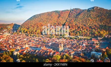 Brasov, Rumänien - Luftdrohnenansicht der historischen Innenstadt, des Rathausplatzes, des Withiten-Turms und der Schwarzen Kirche, herbstliche Landschaft in Siebenbürgen. Stockfoto