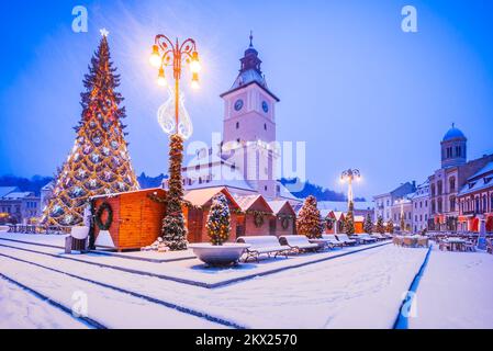 Brasov, Siebenbürgen. Verschneite Winterszene mit Weihnachtsbaum auf dem Hauptplatz, Rumänien. Stockfoto