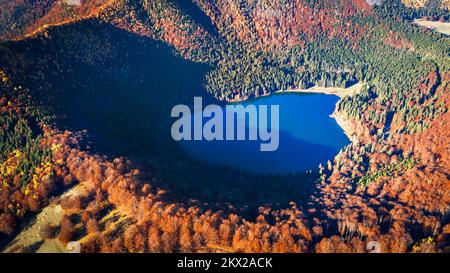 St. Ana Lake, Siebenbürgen, Rumänien. Der schönste vulkanische See in den Karpaten, Siebenbürgen, mit atemberaubenden Herbstfarben. Stockfoto