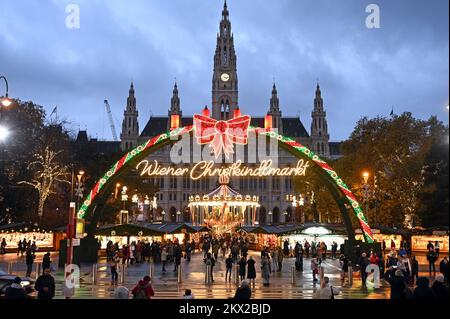 Blick auf den beleuchteten Weihnachtsmarkt vor dem Rathaus in Wien, Österreich; am Abend Stockfoto